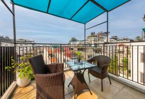 patio con mesa y sillas en el balcón en Bella Rosa Hotel & Travel, en Hanói