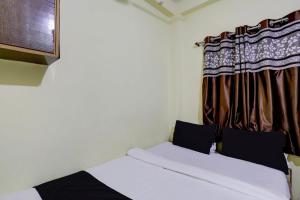 2 camas en una habitación con cortina en OYO Hotel Sai Palace Lodging, en Aurangabad