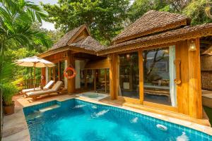 a swimming pool in front of a house at Santhiya Koh Phangan Resort and Spa in Thong Nai Pan Noi