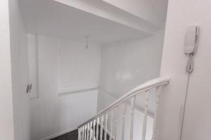 a white staircase with a phone on the wall at May Disc - Long Stay - Contractors in Cardiff