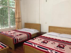 a bedroom with two beds and a window at Hải Quân Motel in Ha Long
