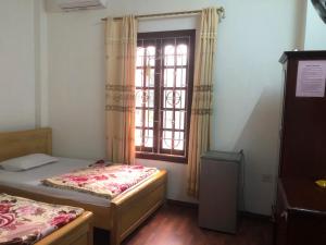 two beds in a room with a window at Hải Quân Motel in Ha Long
