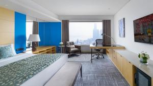 a hotel room with a bed and a desk at Marco Polo Wuhan in Wuhan
