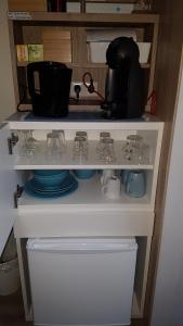 a shelf with dishes and glasses on it at Duin en Zee Texel in De Koog