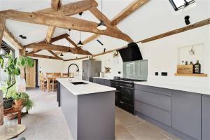 a kitchen with white counter tops and wooden ceilings at The Cart House - Rural Retreat in Hereford