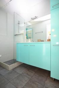 ein Badezimmer mit einem blauen Schrank und einem Spiegel in der Unterkunft Icon Painter Villa 'Peroulia 4' in Kómboi