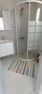 baño con ducha y alfombra a rayas en Relax, en Pírgos