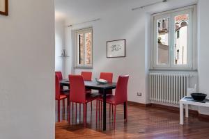 ein Esszimmer mit einem Tisch und roten Stühlen in der Unterkunft Medici Chapels Apartment in Florenz