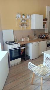 uma cozinha com armários brancos e um forno com placa de fogão em Cosy em Vršac