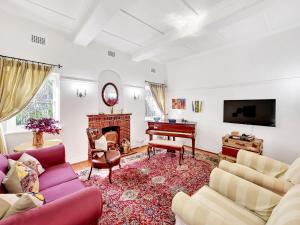 sala de estar con sofá y piano en Charming Family Home, en Ciudad del Cabo