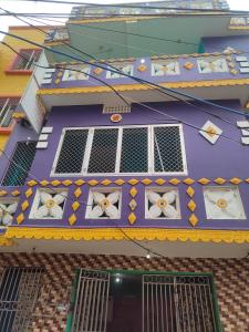 un edificio con tetto viola, finestre e aocr di JHARANA GUEST HOUSE a Puri