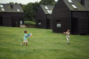 two children playing with a frisbee in a yard at Domki Momenty in Słajszewo