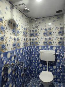 uma casa de banho azul e branca com um WC em JHARANA GUEST HOUSE em Puri