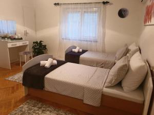 a bedroom with two beds and a window at Holiday Home Matija in Ljubuški