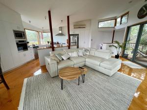 a living room with a white couch and a table at The Treehouse at Sellicks Hill in Sellicks Hill
