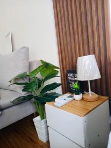 a side table with a lamp and a plant on it at ECO Staycation - En Casa Orila in Manila