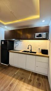 uma cozinha com um lavatório e um micro-ondas em ECO Staycation - En Casa Orila em Manilla