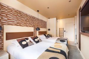 sypialnia z 2 łóżkami i ceglaną ścianą w obiekcie Charming apartment in the heart of the Marais w Paryżu