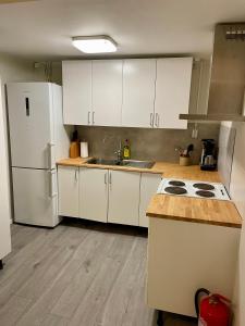 a kitchen with white cabinets and a white refrigerator at Fiskebäckgårds gästhus in Lysekil