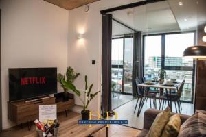 a living room with a tv and a table with chairs at The Executive Suite - By Parydise Properties - Business or Leisure stays - Sleeps 2 - Deansgate, Manchester in Manchester