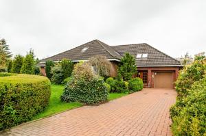 ein Haus mit einer gepflasterten Auffahrt davor in der Unterkunft Haus Störtebeker in Marienhafe