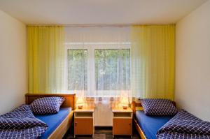 ein Schlafzimmer mit zwei Betten und einem Fenster in der Unterkunft Haus Störtebeker in Marienhafe