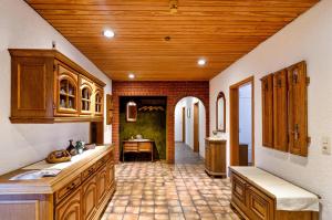 eine Küche mit Holzschränken und Fliesenboden in der Unterkunft Haus Störtebeker in Marienhafe + 15 Fotos