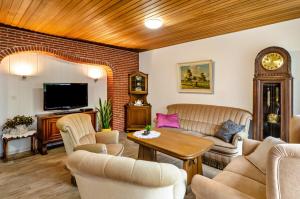 ein Wohnzimmer mit einem Sofa und einer Uhr in der Unterkunft Haus Störtebeker in Marienhafe