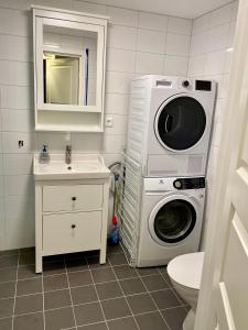 ein Badezimmer mit einer Waschmaschine und einem Waschbecken in der Unterkunft Fiskebäckgårds gästhus in Lysekil