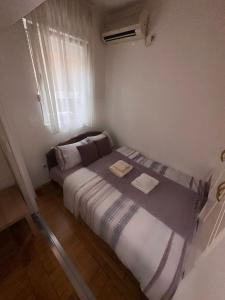 Habitación pequeña con cama y ventana en Apartment Boulevard, en Belgrado