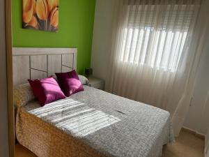 マサロンにあるCarolina apartamento de Luxeの緑のベッドルーム(紫色の枕が付いたベッド付)