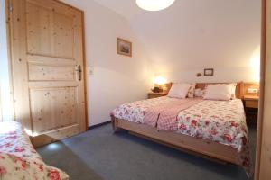 a bedroom with a bed and a door at Landhaus Nockalm in Bad Kleinkirchheim