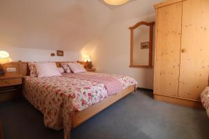 a bedroom with a bed and a dresser and a mirror at Landhaus Nockalm in Bad Kleinkirchheim