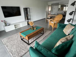 sala de estar con sofá verde y mesa en Modern & großzügig! Ideal für Familie & Arbeit en Linden
