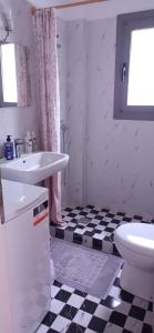 uma casa de banho branca com um lavatório e um WC em D & X Home em Atenas