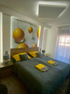 a bedroom with a large bed with yellow pillows at Pegazus Apartman in Keszthely