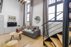 ein Wohnzimmer mit einem Sofa und einem Tisch in der Unterkunft Parisian duplex cocoon in Saint-Germain-Des-Pres in Paris