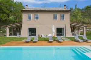 une maison avec une piscine en face d'une maison dans l'établissement Villa Gea 12, à Fermignano