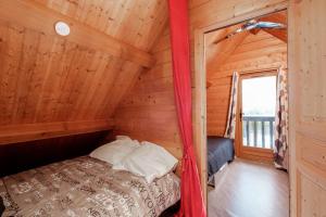 a bedroom with a bed in a log cabin at Le Chalet Boisé - Maison avec jardin clôturé in Montoldre