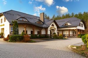 a large white building with a black roof at Złota Jesień Restauracja i Noclegi nad jeziorem in Kartuzy