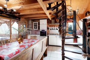 a kitchen with wooden ceilings and a dining table at Le Chalet Boisé - Maison avec jardin clôturé in Montoldre