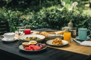 einen Holztisch mit Teller mit Speisen und Getränken in der Unterkunft Avana Retreat in Mai Châu