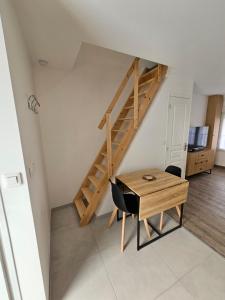 a room with a wooden table and a wooden stairs at Chez Ernestine in Nanteuil-lès-Meaux