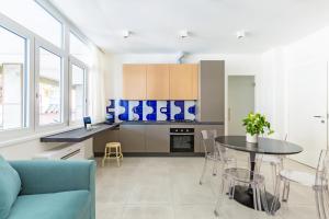 une cuisine avec une table et un canapé bleu dans l'établissement Starhost - Mazzini Apartments, à Salerne
