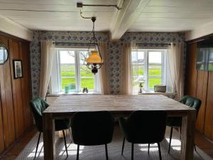 a dining room with a wooden table and chairs at Huus Hannchen in Langeneß