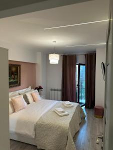 una camera da letto con un grande letto bianco e una finestra di CassaTa-one-Vaslui a Vaslui