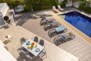 an overhead view of a patio with a table and chairs by a pool at Azure Luxury Pool Villa in Protaras