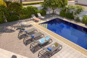 una vista aérea de una piscina con sillas y una mesa en Azure Luxury Pool Villa en Protaras