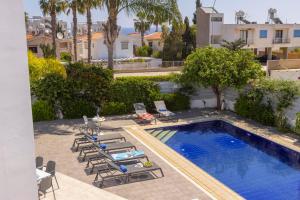 una piscina con tumbonas y una piscina en Azure Luxury Pool Villa en Protaras