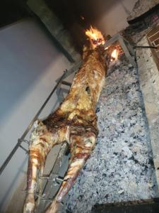 een groot stuk vlees koken op een grill bij Restorant Ballkoni Beratit in Berat